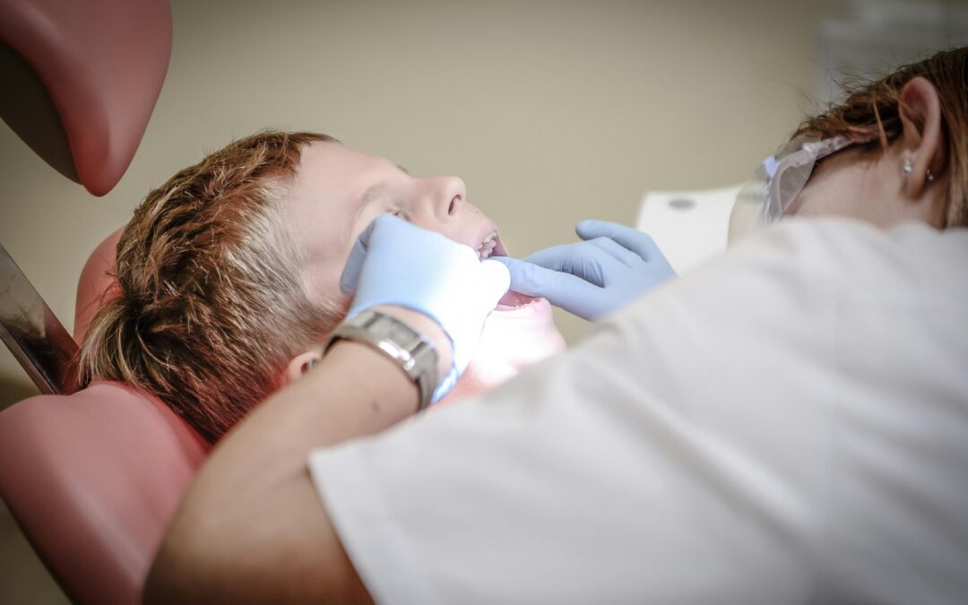 boy leaned back with dentist looking into his mouth