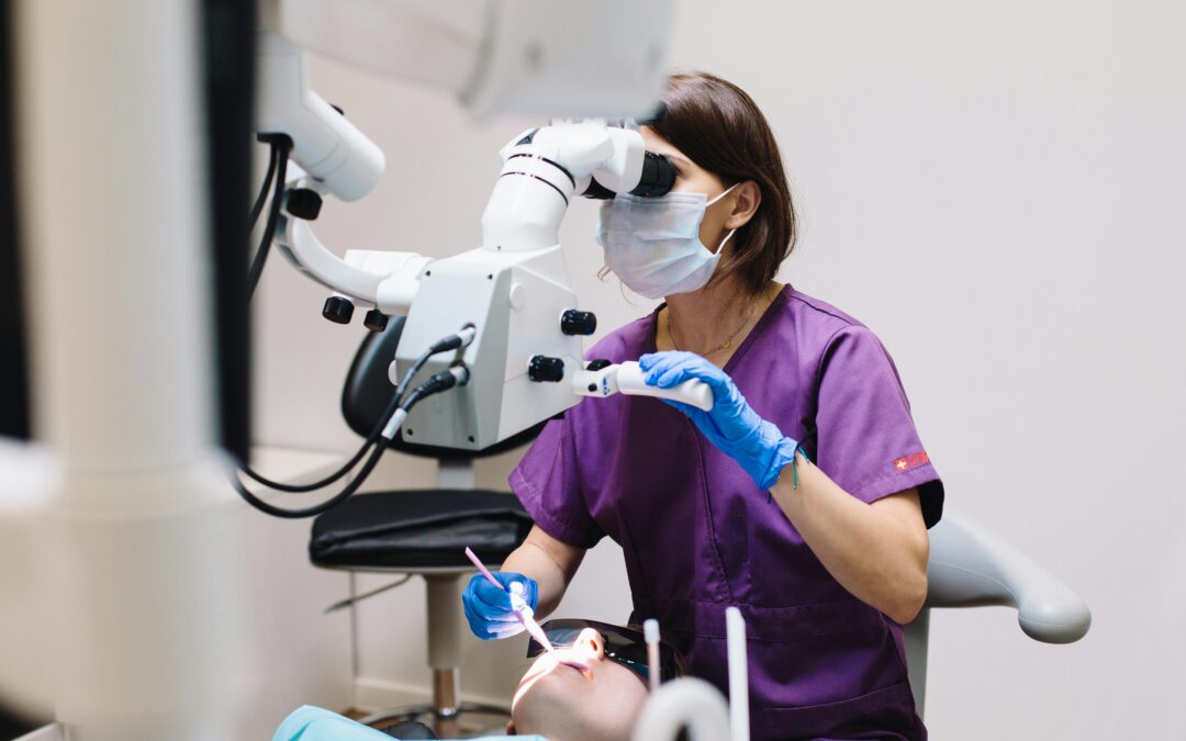 a dentist with mask and x-ray machine over someone sitting in the dental chair